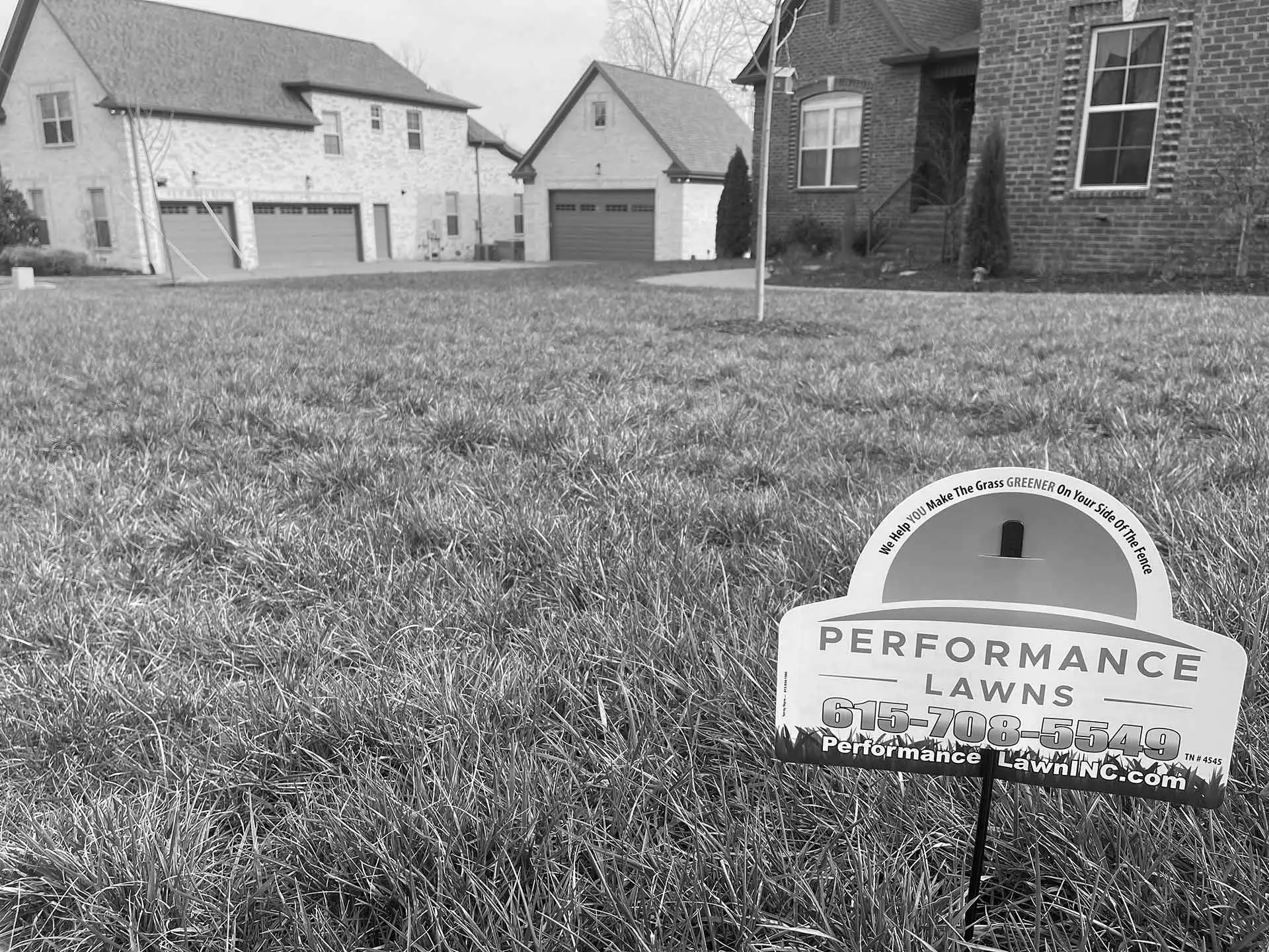 Black and white photo of a lawn with a lawn care company yard sign near Gallatin, TN.