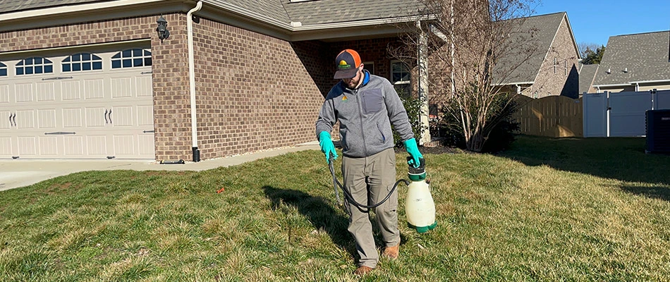Technician spraying weed control treatment to a lawn in Gallatin, TN.